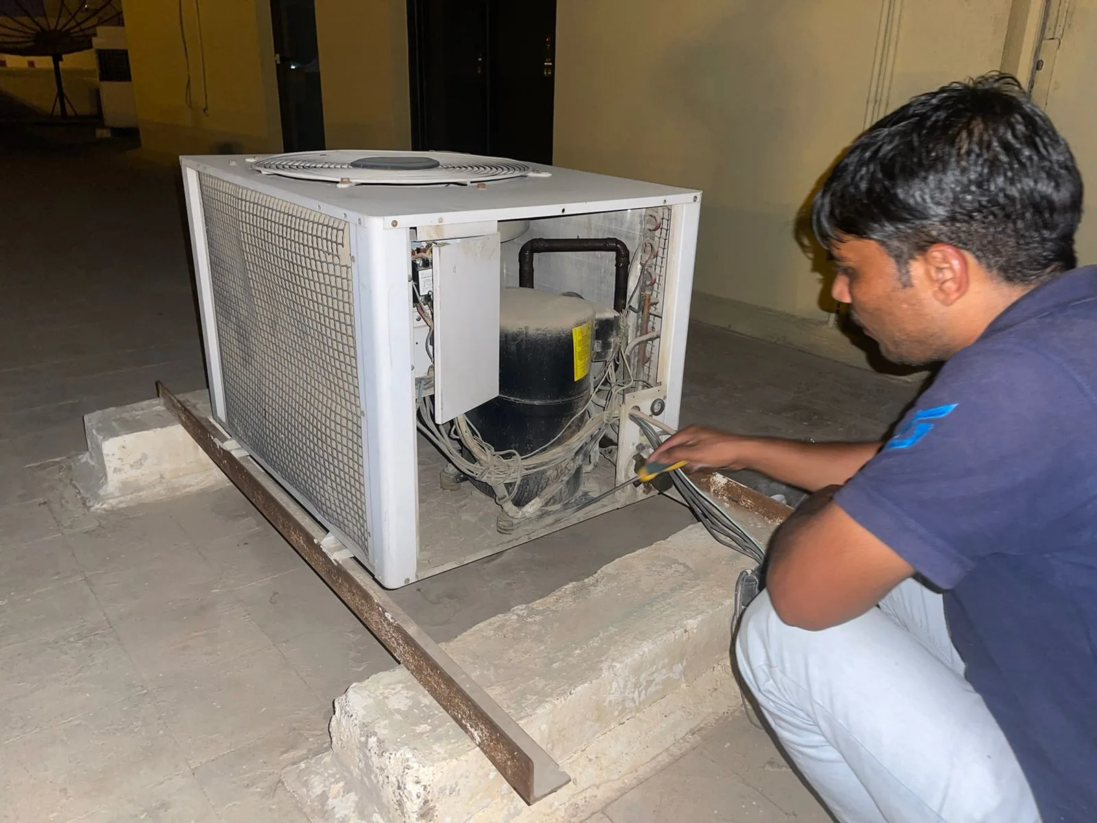 Samra Facilities technician servicing a residential AC unit in Dubai