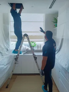Samra technician vacuuming an AC duct interior