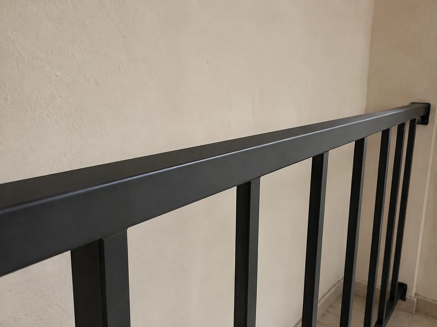 Stair railing and metal balustrade repainted in black satin over a rust-inhibiting primer