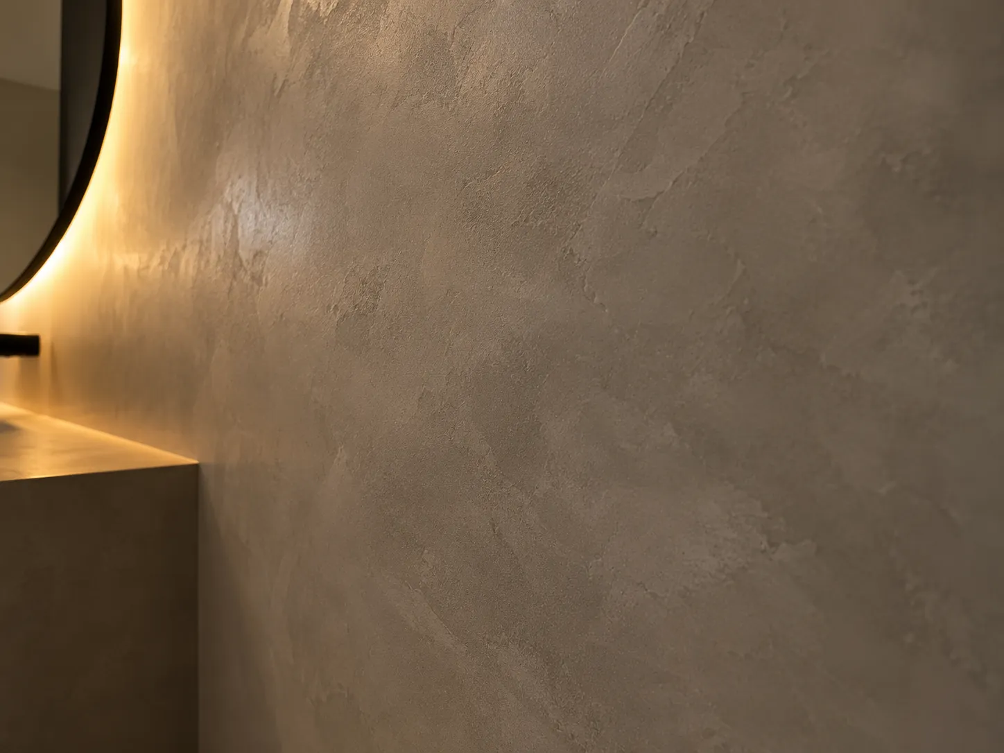 Microcement bathroom wall in Dubai finished in a warm neutral with continuous surface and no grout lines